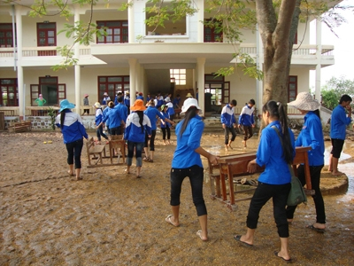 Lực lượng tình nguyện đang giúp chùi rửa bàn ghế ở trường tiểu học Quảng Minh B