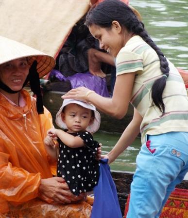 Dù trời mưa nhưng những đứa trẻ này cũng theo bà ra sông cổ vũ&nbsp;